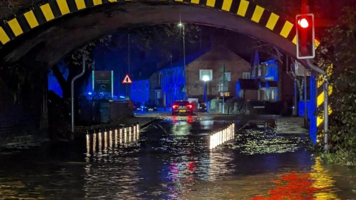 Floodwaters fill the dip under a bridge at night