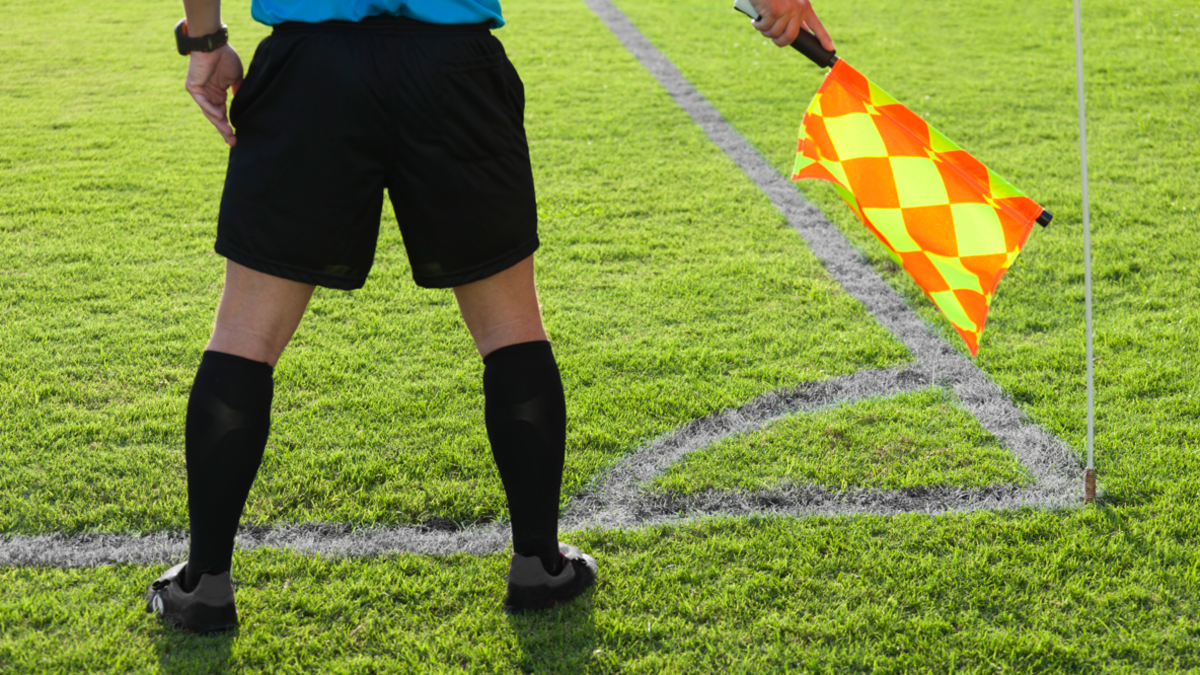 Football assistant referee stood on a pitch