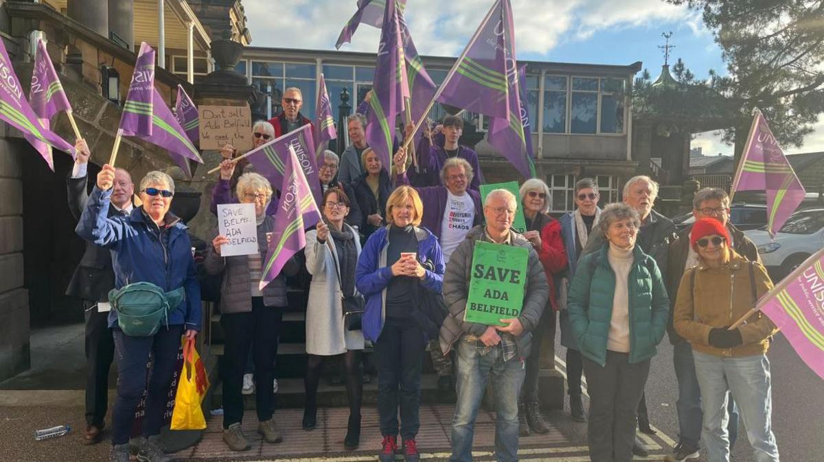 People outside County Hall in Matlock protesting against the closures. Some are waving purple UNISON flags. 