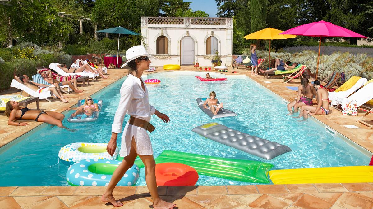 People relaxing by a French swimming pool