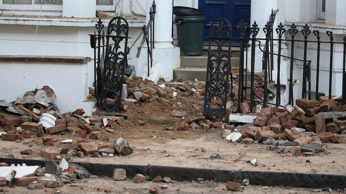 Rubble covers the front entrance and pavement outside one of the properties.