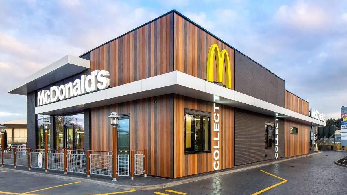 A McDonald's branded drive-thru restaurant with car lanes and a seating area.