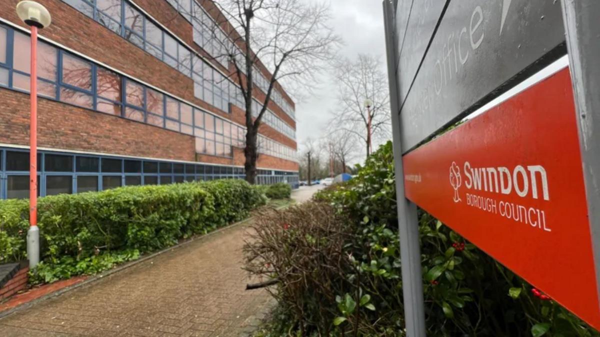 A Swindon Borough Council sign in front of an office building