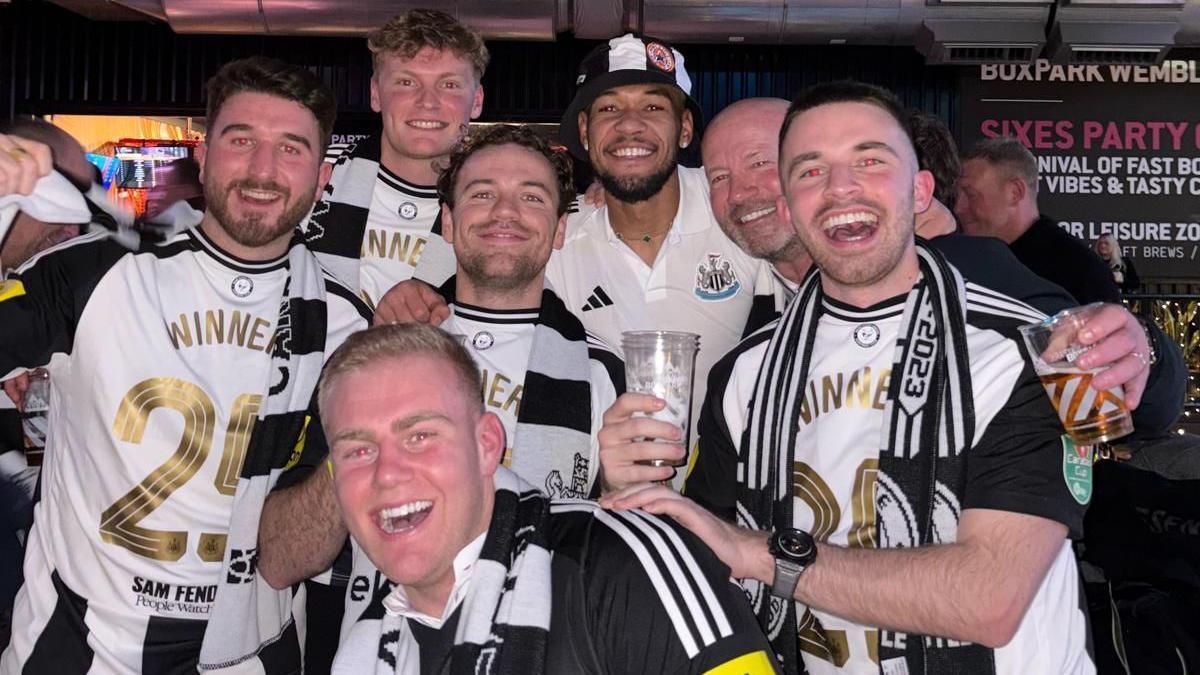 Alan Shearer (2nd from right) and his lad   Will (far right) joined fans to enactment      with Newcastle midfielder Joelinton (3rd from right)