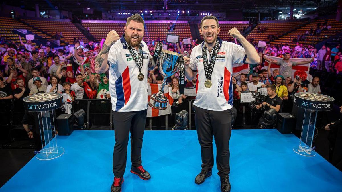 Michael Smith and Luke Humphries celebrate with the 2024 World Cup of Darts trophy