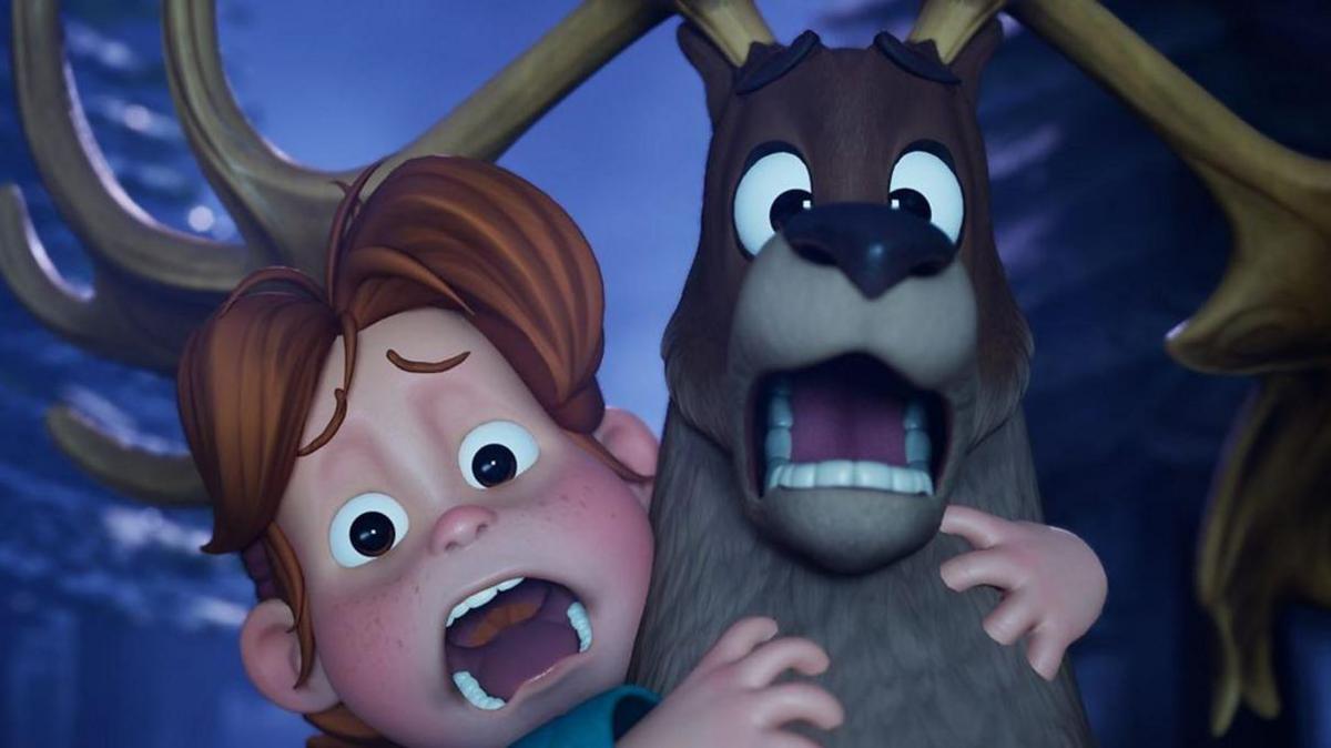 The characters Nollaí and Sadhbh, both appear to be scared with their mouth opened. Nollai is a brown deer and Sadhbh is a young girl with ginger hair. Behind them is dark trees and the night sky. 