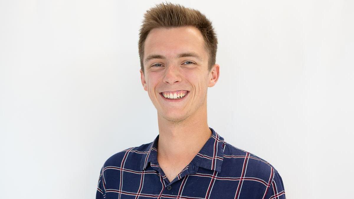 Head and shoulders shot of William Laven smiling and wearing a blue and white checked shirt