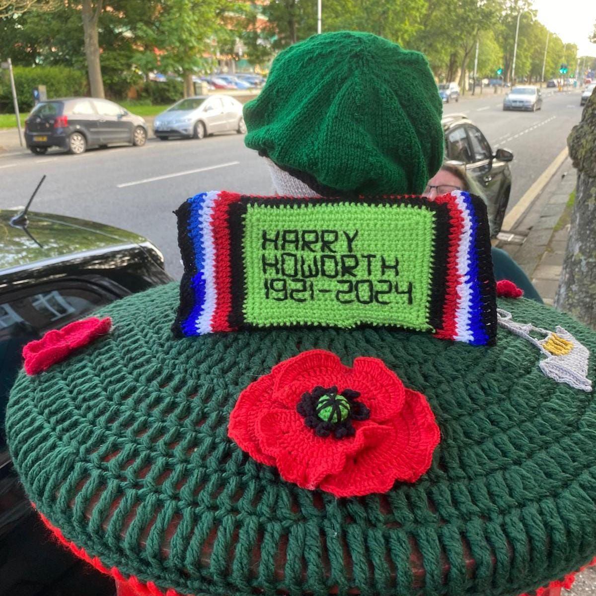 A crochet model of a green beret with the caption 'Harry Howorth 1921 to 2024'