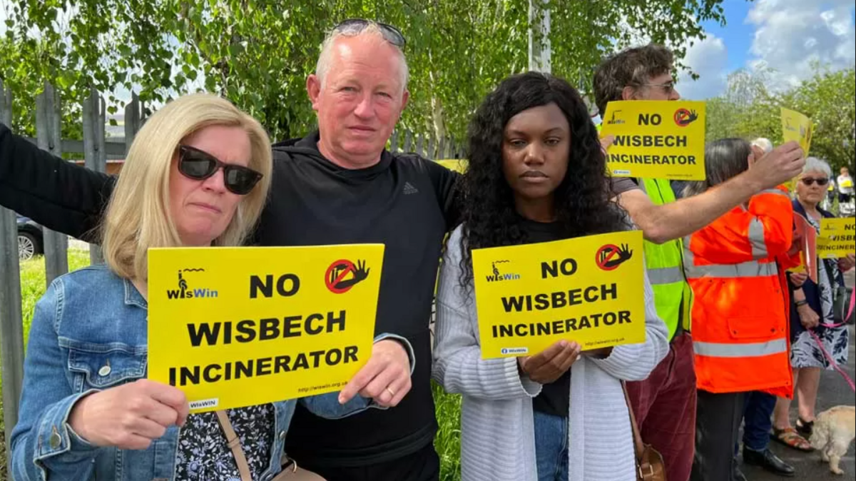 People holding yellow placards saying 'no Wisbech incinerator' on them