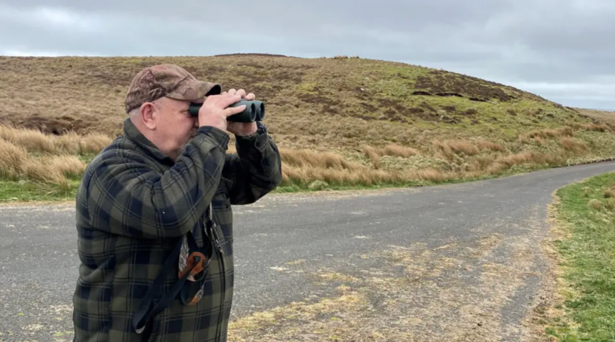 Ian Glendinning looking through binoculars.