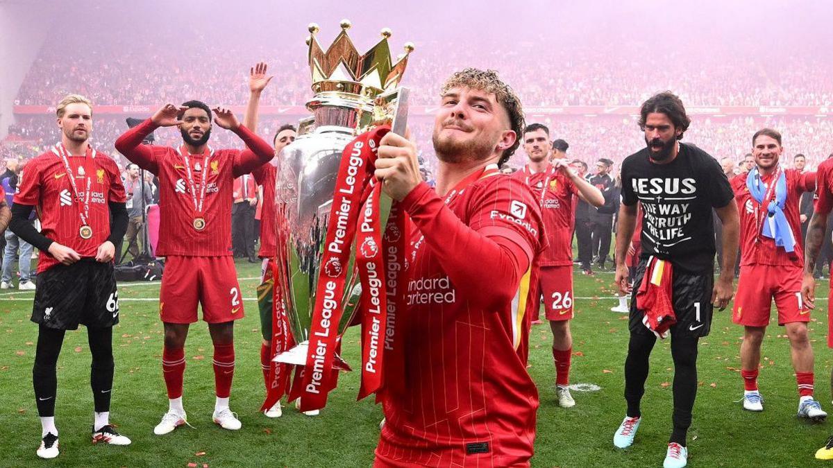 Liverpool midfielder Harvey Elliott lifts the Premier League trophy
