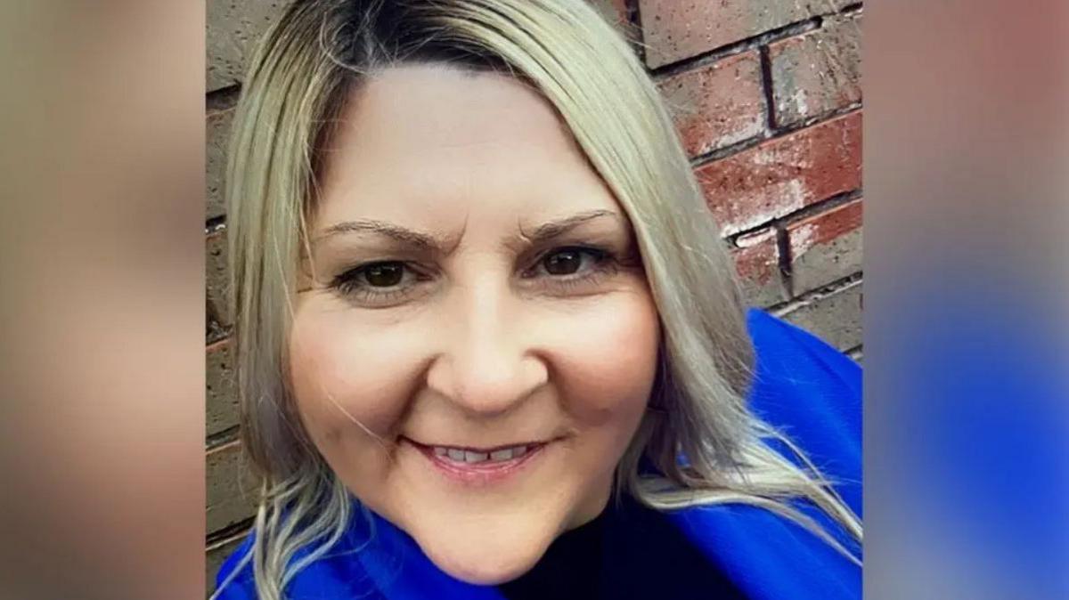 A smiling woman looking at the camera.