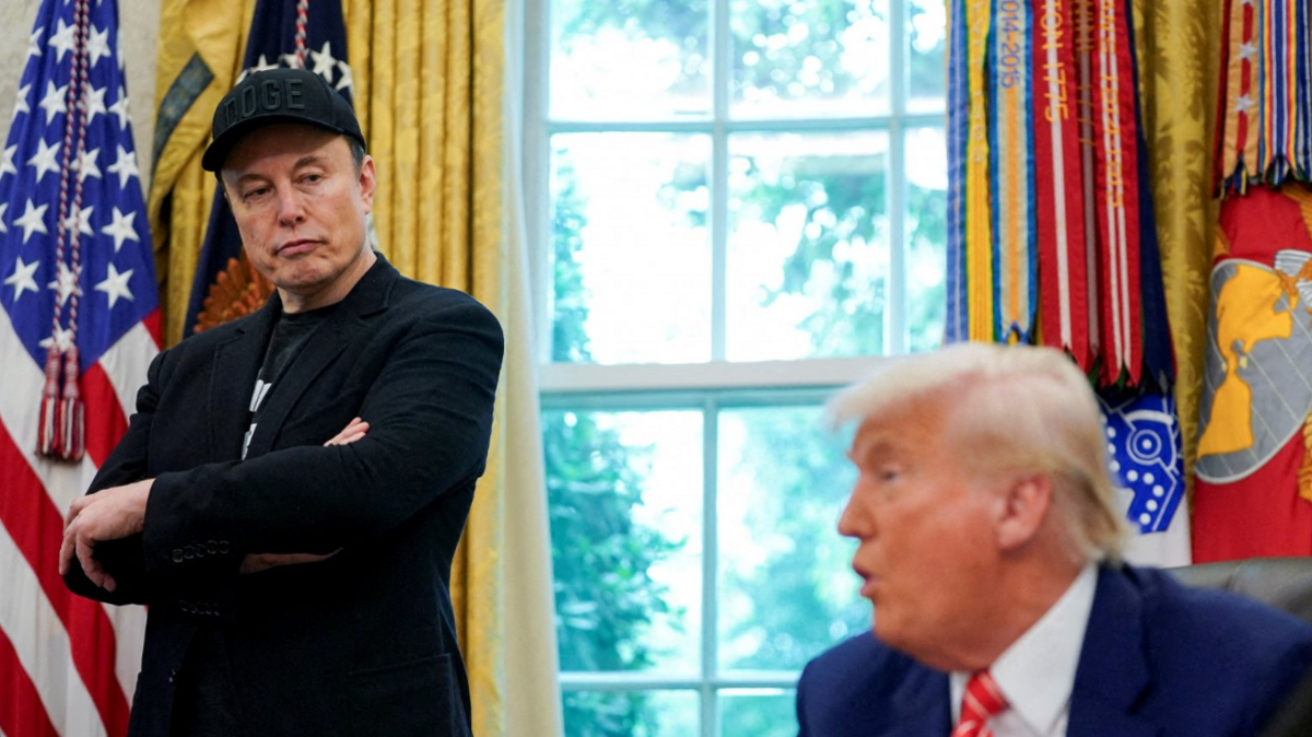 Musk looking at Trump, seated in the Oval Office