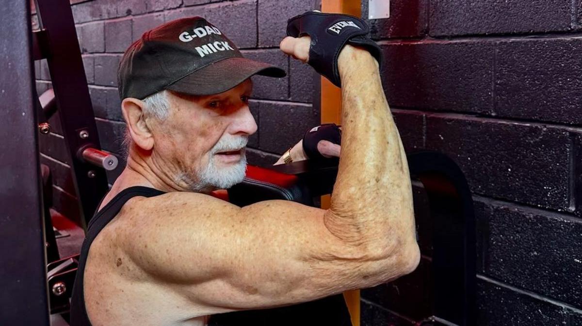 Mick Wadge flexes his right arm while using a weight-training machine at the gym.
