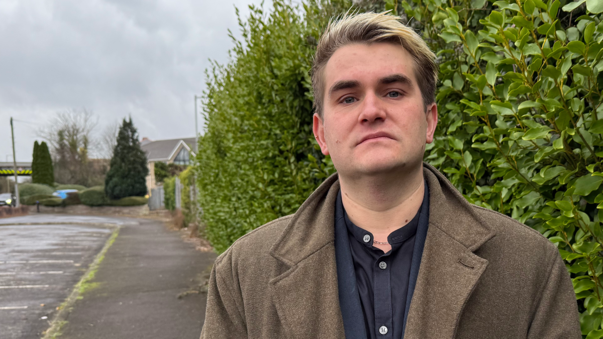 Jake Hurfurt, of Big Brother Watch, standing between a road and a hedge, looks at the camera