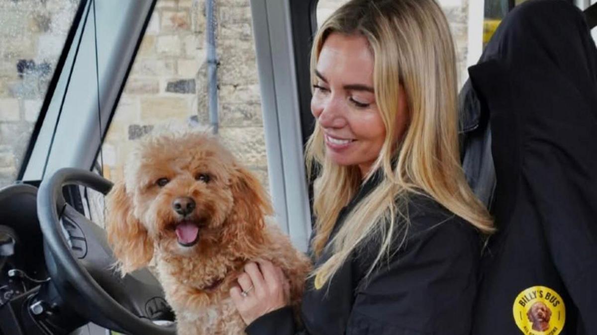 Laura and her dog billy sitting in the bus driver seat
