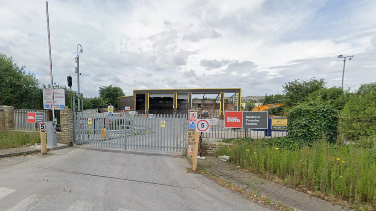 The entrance to Biffa's Bradford transfer station, with a grey gate closed to prevent access. A barrier is raised, with a great deal of signage around the entrance. They include a 5mph speed limit sign and a notice reading "Biffa Bradford Transfer Station".