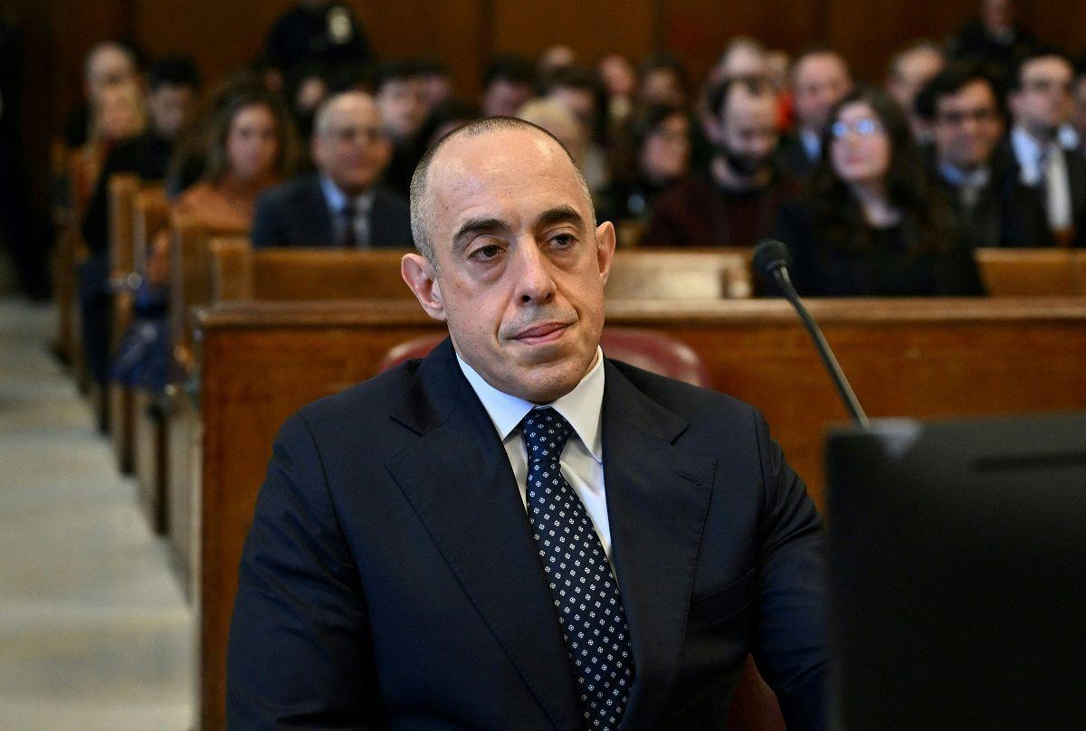 A man in a suit sitting in a courtroom