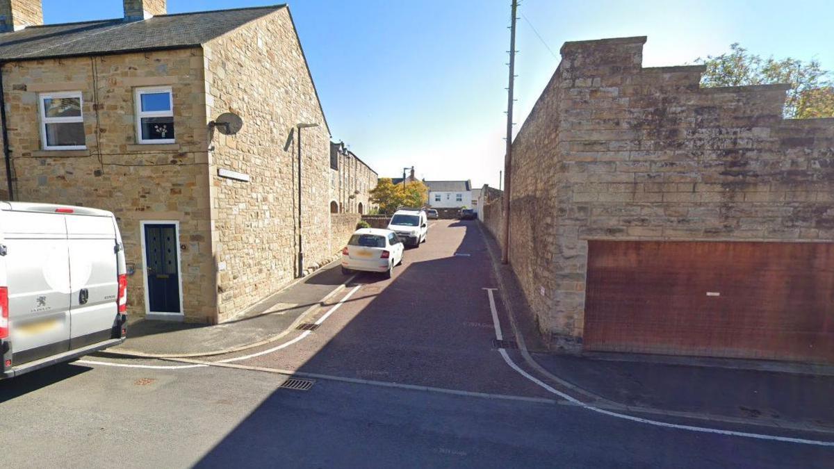 A street view of Vere Road's junction with Commercial Yard, showing the current parking restrictions. The is a single white line along parts of the road.