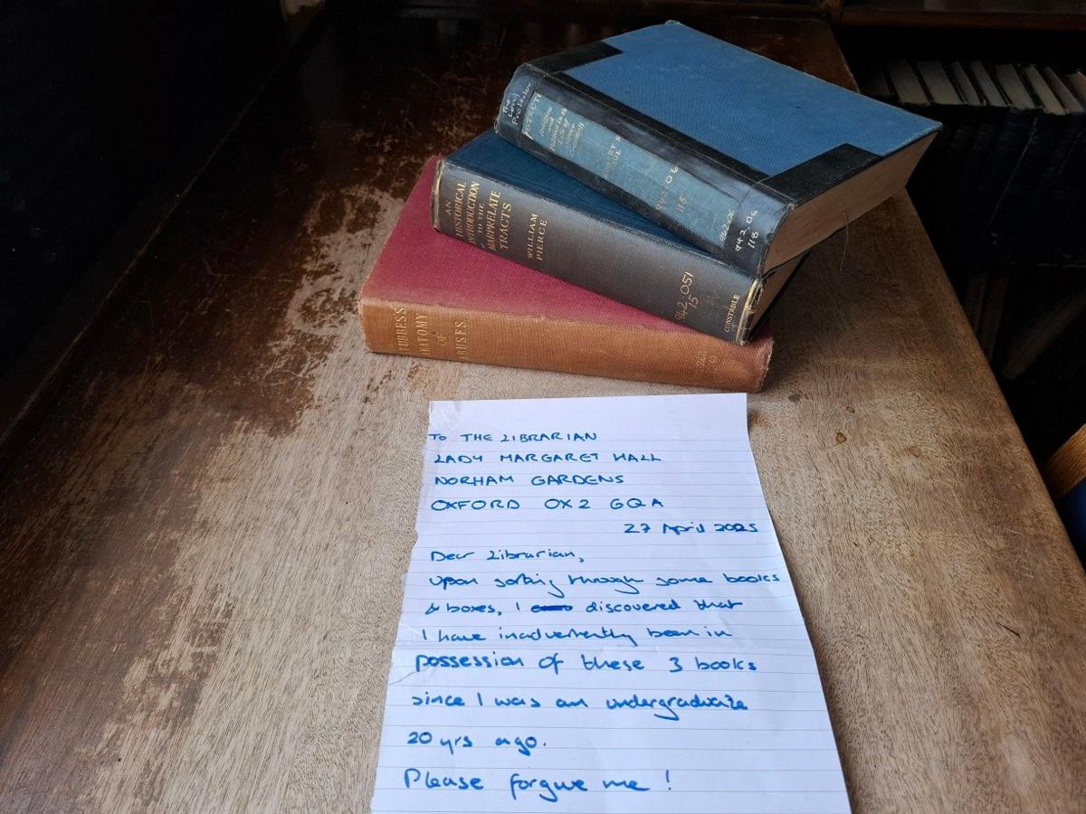 Three library books and a note.