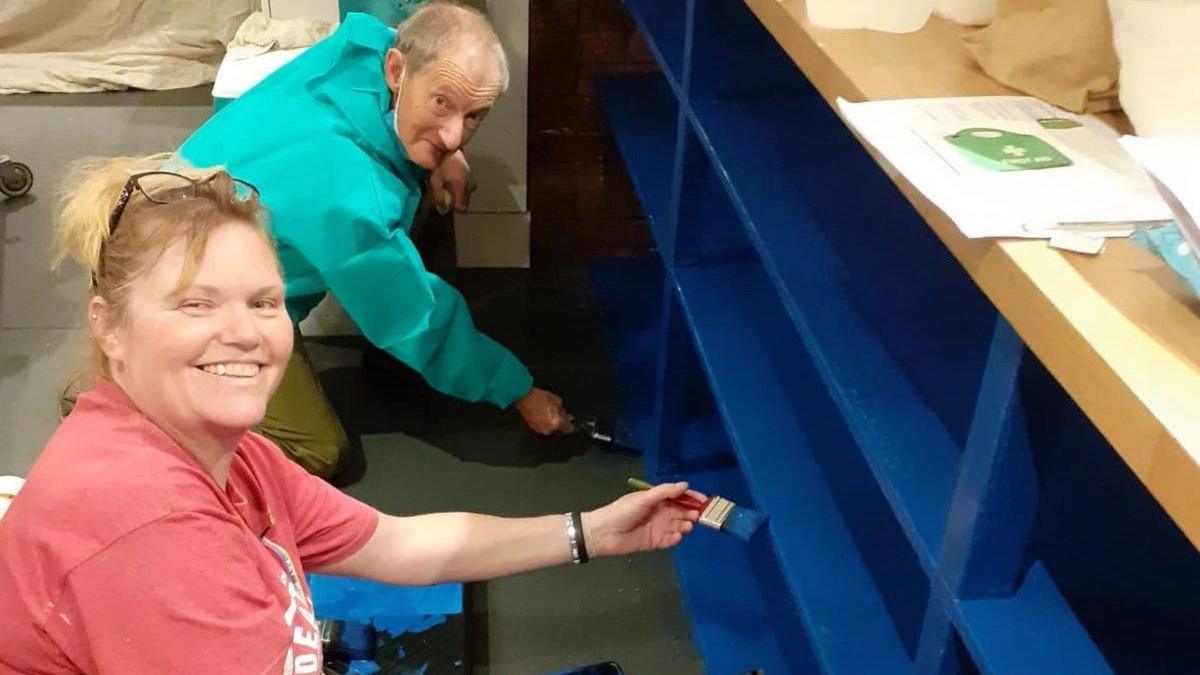 Ark volunteers painting shelves