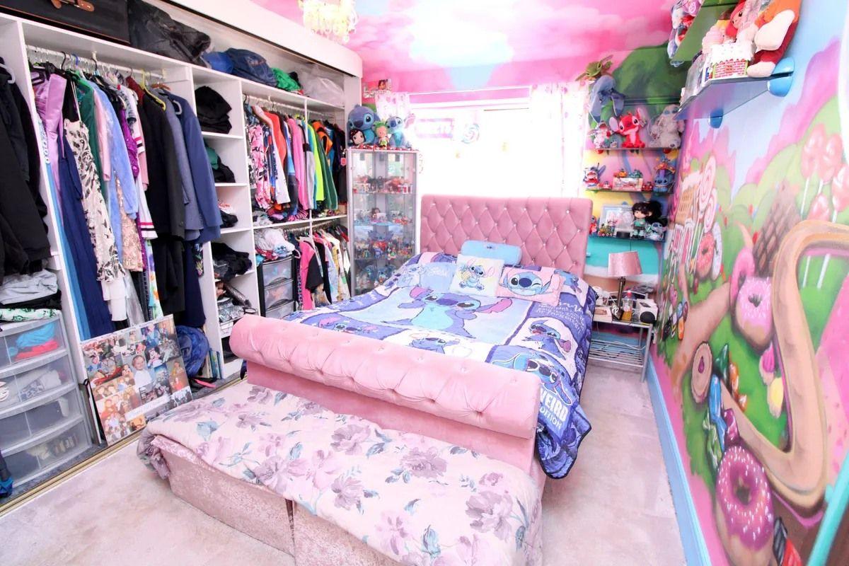 A pink bedroom decorated with a brightly-coloured mural of cakes and sweets