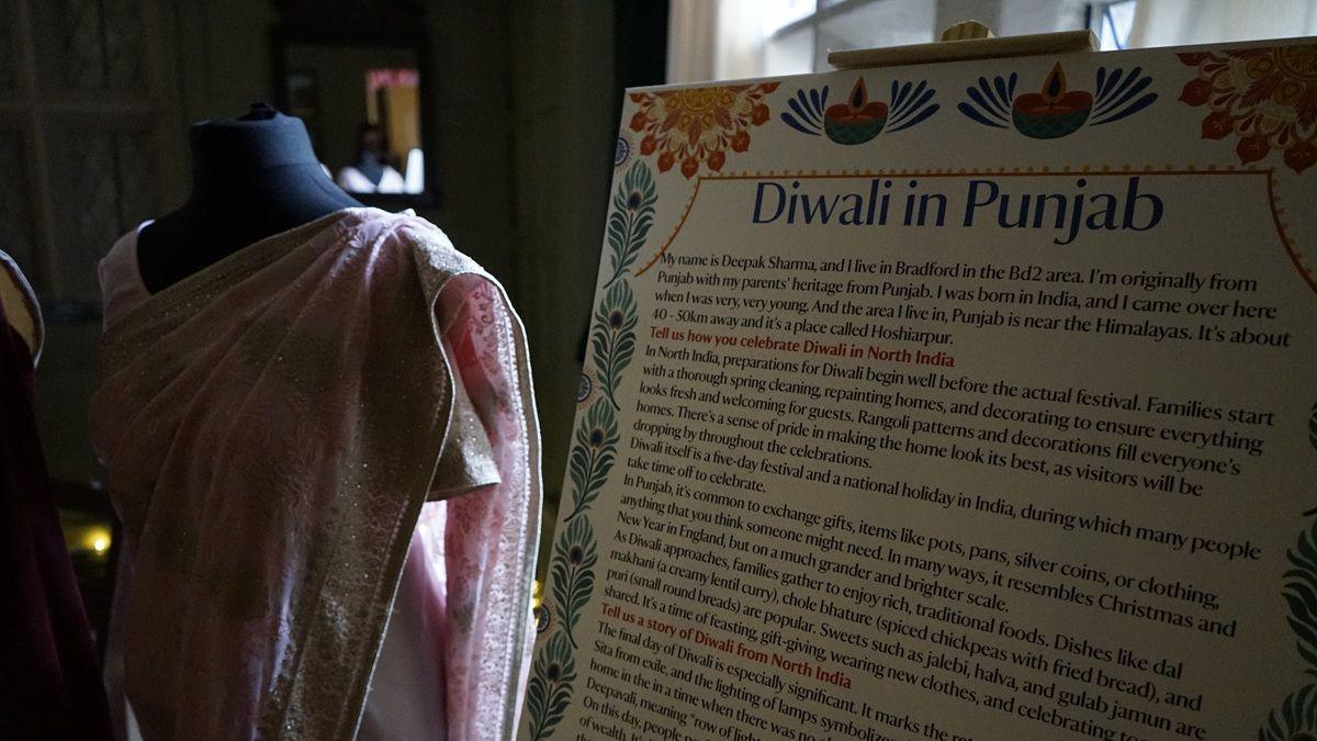 A board with lots of text, with the title "Diwali in Punjab" at the top. Next to it is a light pink sari on a mannequin, with silver and gold trims.