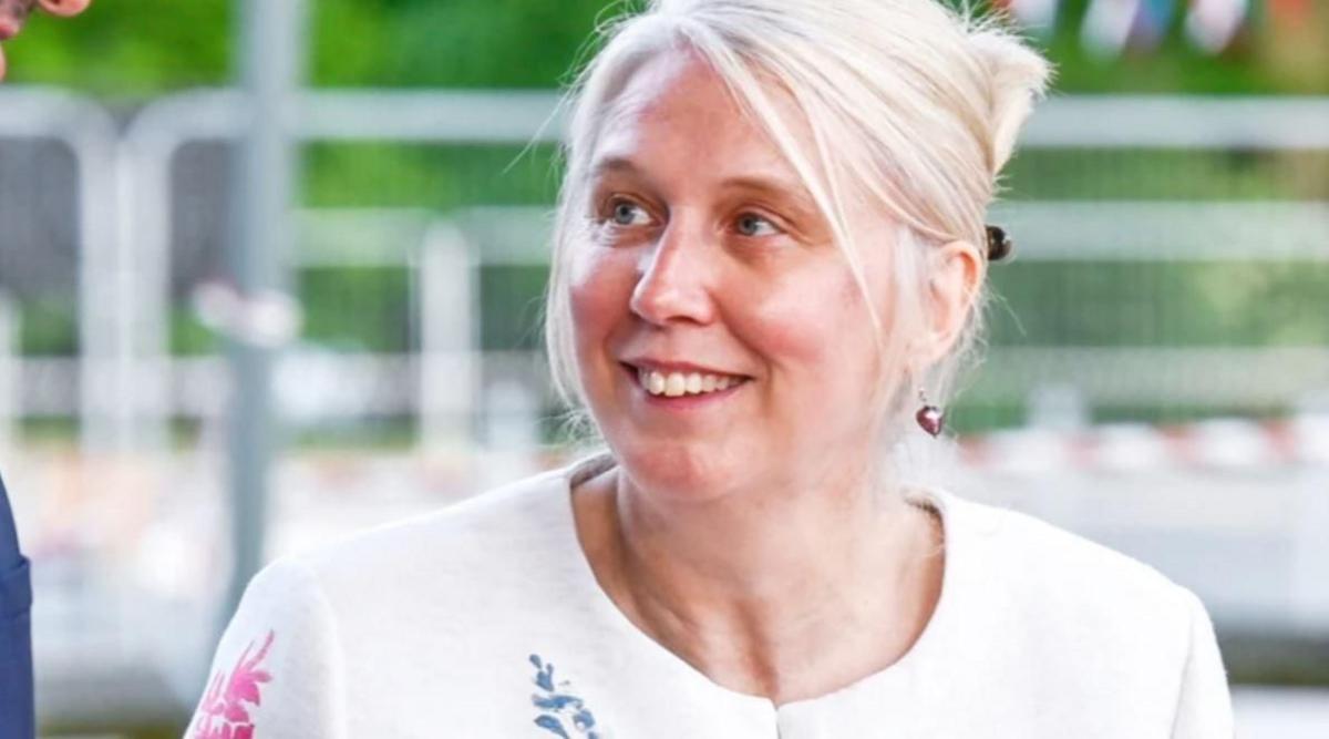 A woman with pale blonde hair and a white top looking upwards slightly