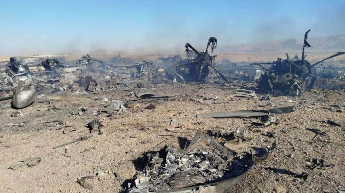 A still image purporting to show the burned wreckage of aircraft destroyed during the US mission to find a stranded airman in Iran. What appears to be two propellers can be seen among scraps of metal and smoke on a sandy ground.