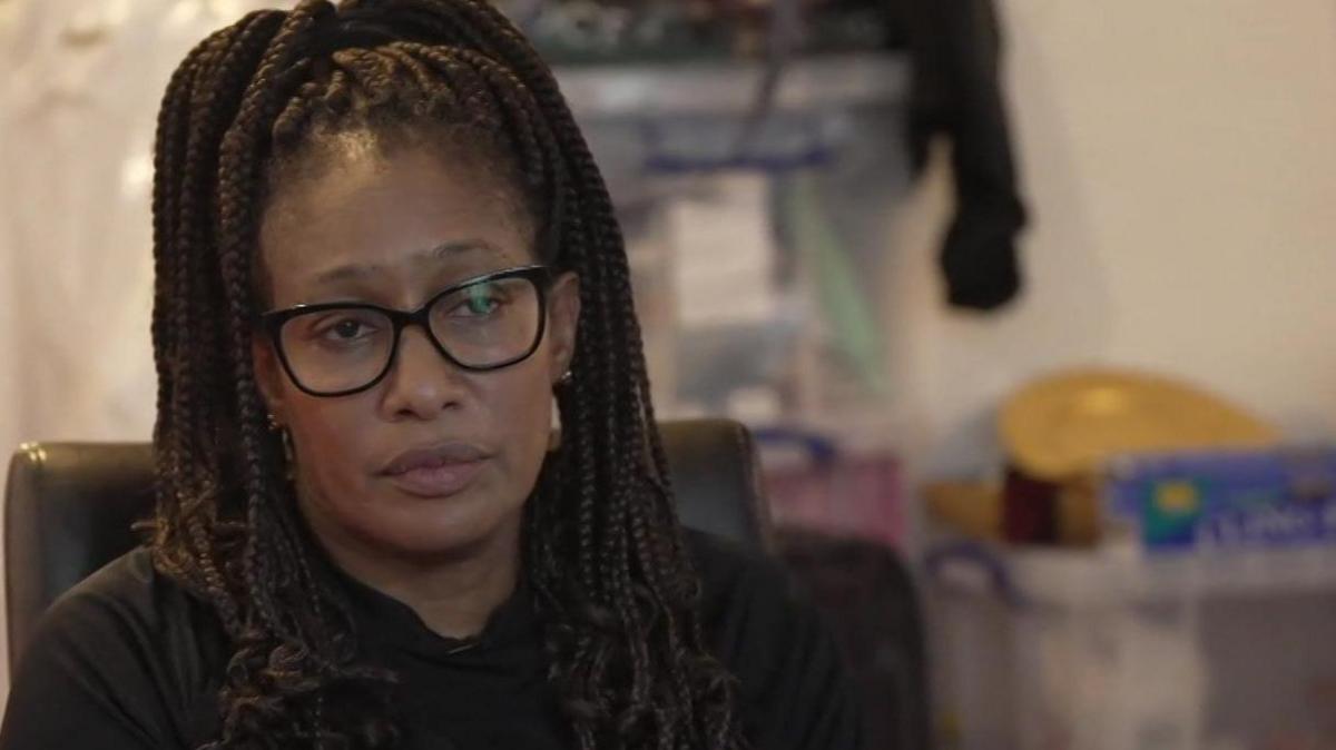 Andie Williams in a black t-shirt. She has dark-framed glasses.