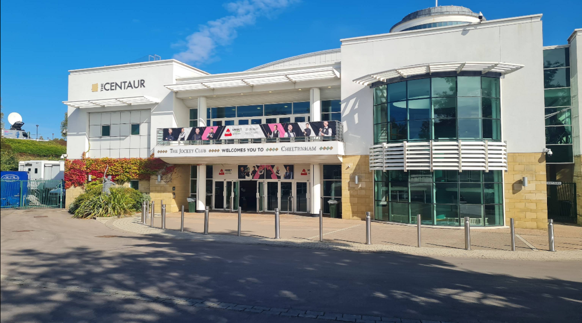 The entrance to the Centaur on a sunny day. The building is made from white concrete and yellow bricks.