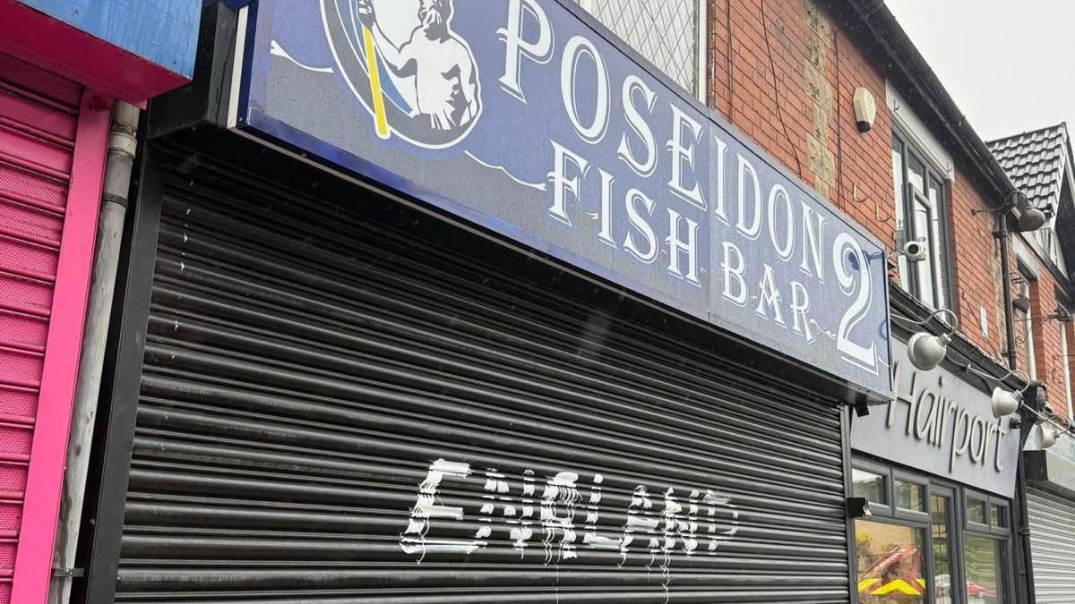 A shop shutter with the word England spray painted onto it