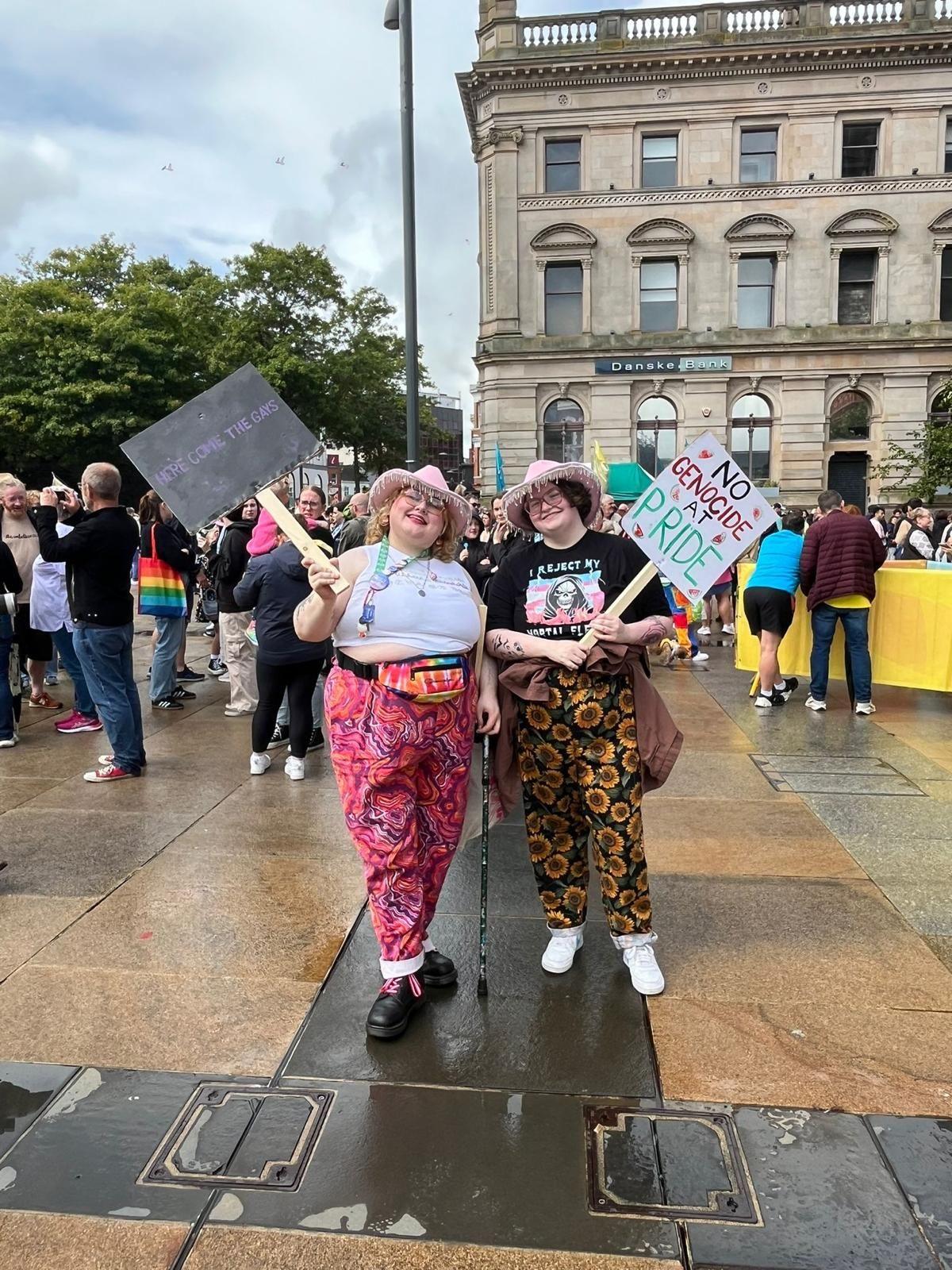 Participants at Foyle Pride, two people holding anti-genocide signs