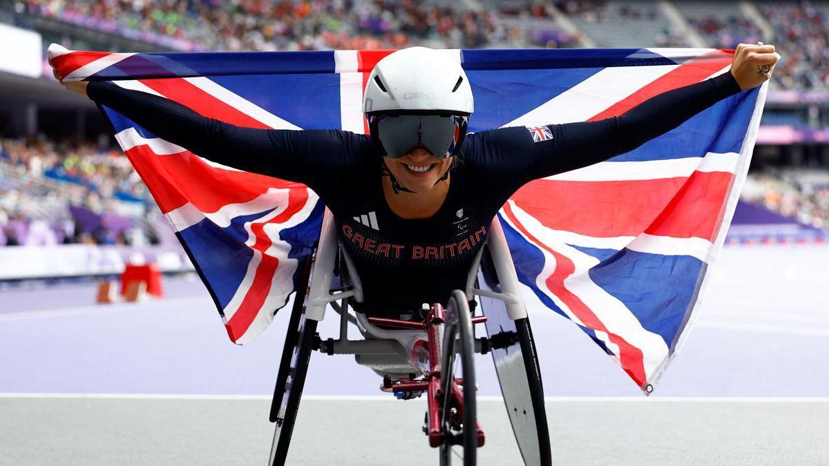 Samantha Kinghorn on the track holding a Great Britain flag