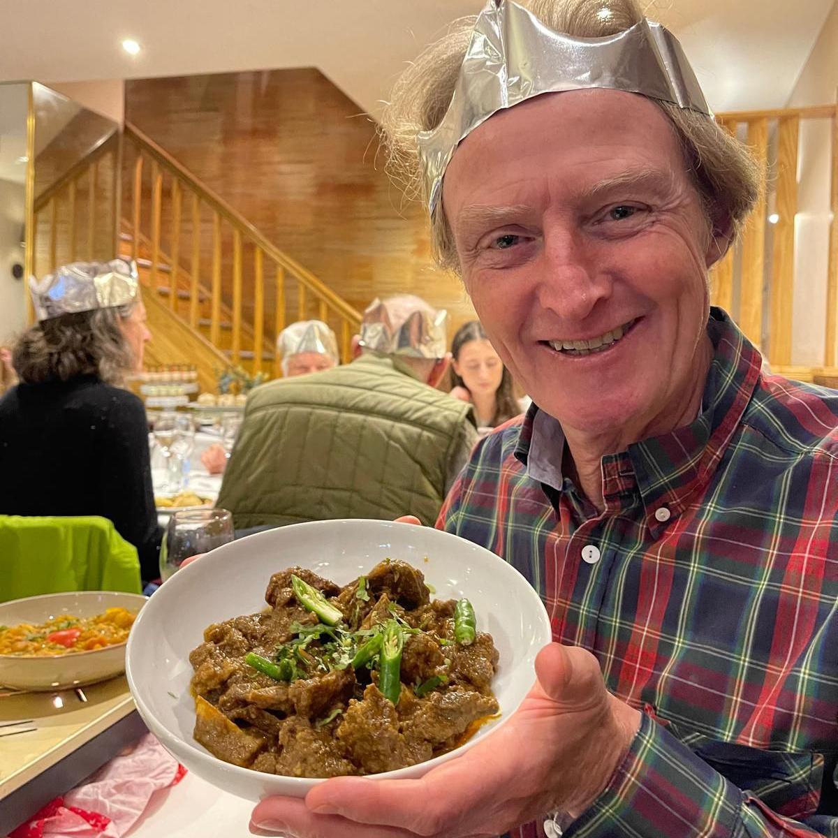 Tim Hartley gyda chyri o fwyty Indiaidd y Bay Leaf yn Llandaf, Caerdydd ar ddydd Nadolig y llynedd