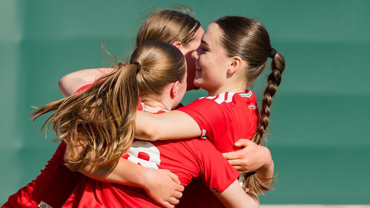 Wales' Cadi Griffiths celebrates scoring with two Wales under-17s teammates