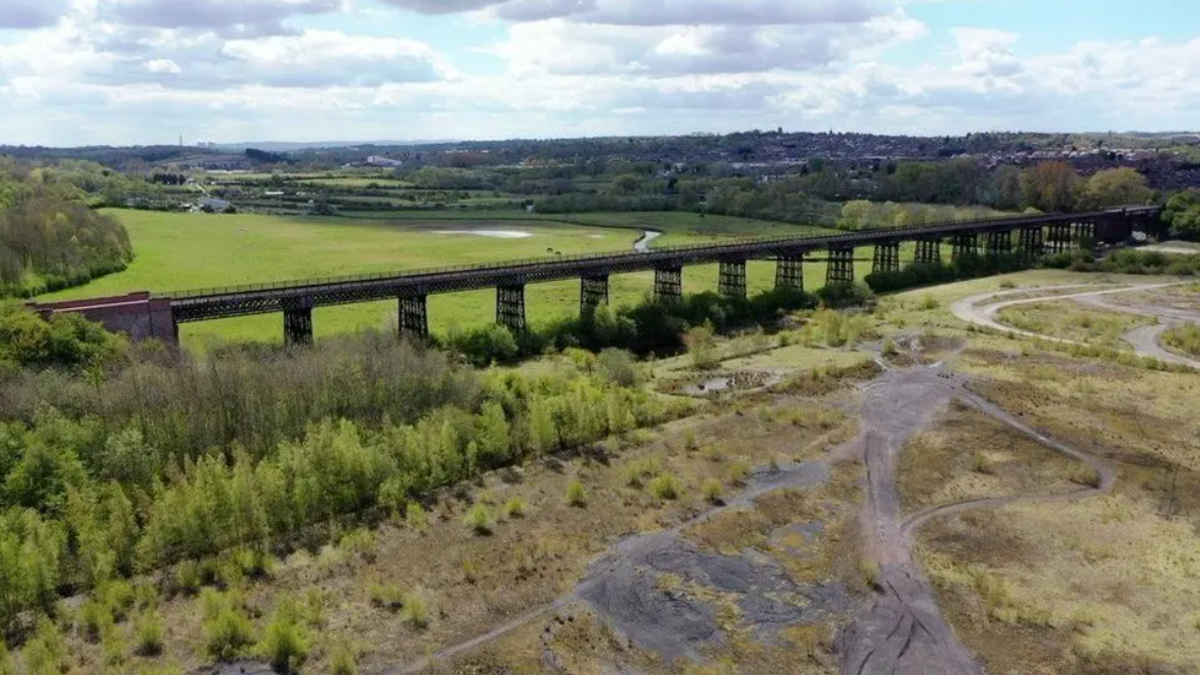 Long viaduct running through the middle of a large field 