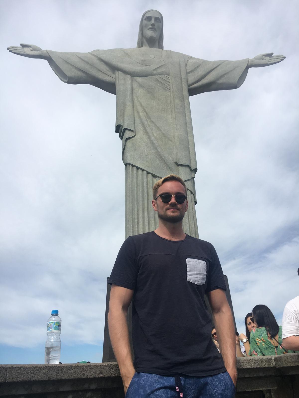 a picture of Denis standing by the Christ the Redeemer statue in Rio de Janeiro
