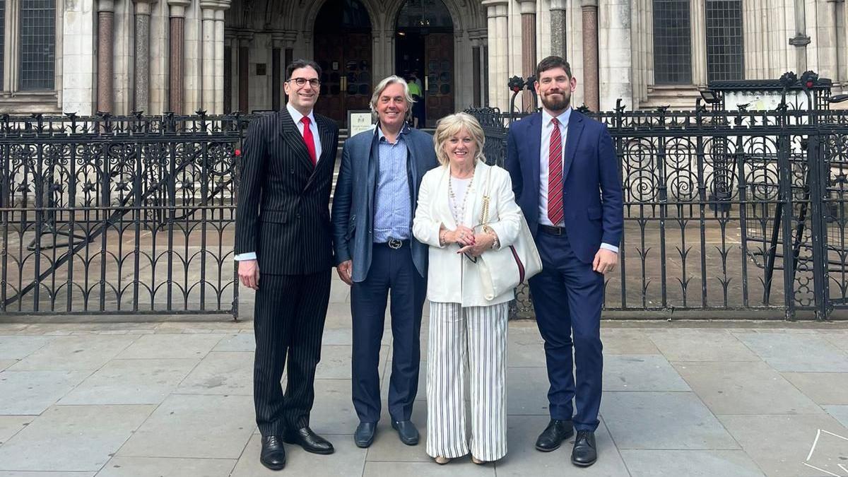 Mark and Rhian Phillips (both centre) smiling outside the court with their solicitors 