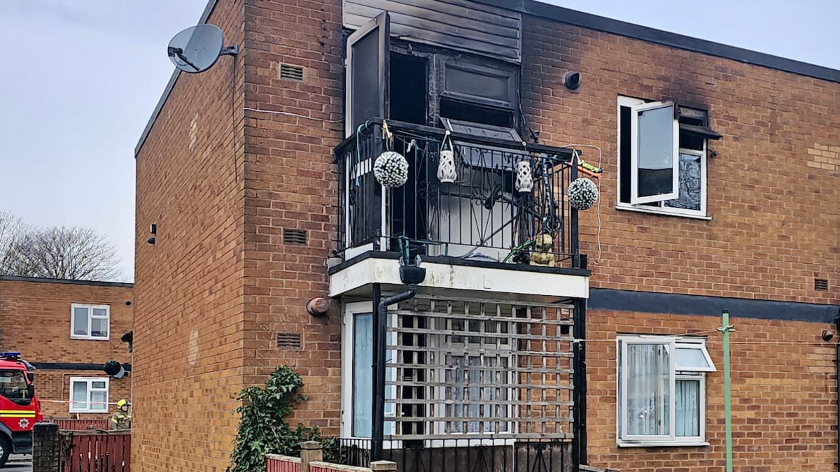 The exterior of the maisonette, showing fire damage to the brickwork