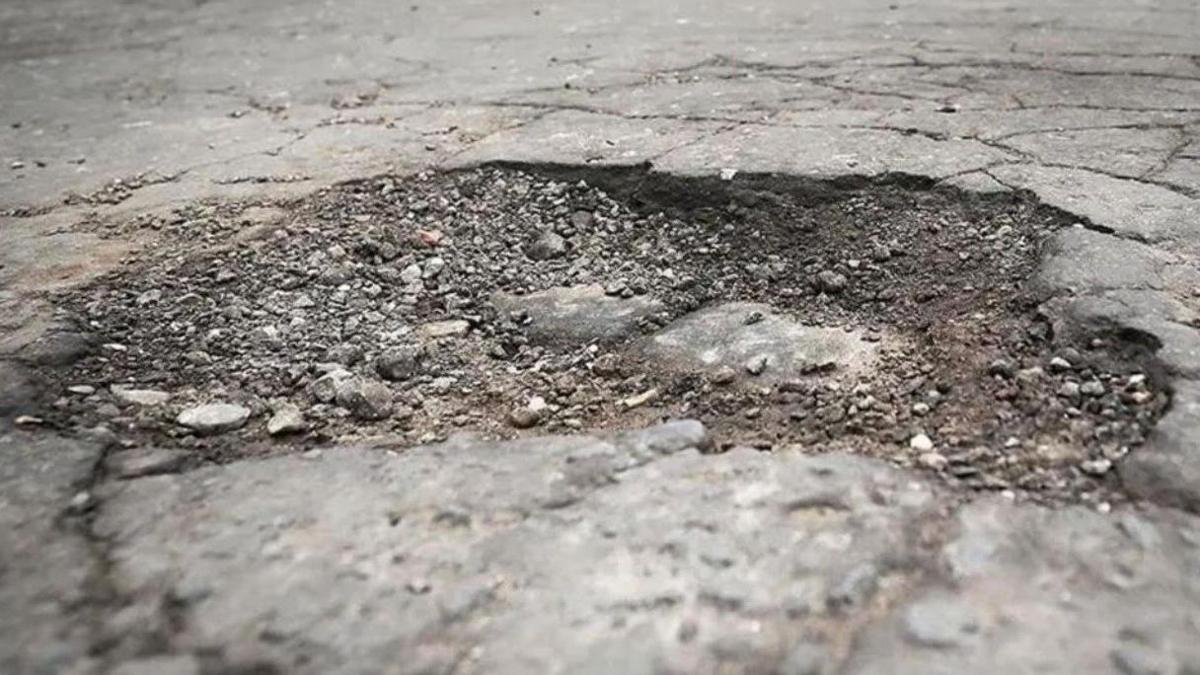 Generic image of a pothole. It is prominent on the photo, with the road around it filling the rest of the image.