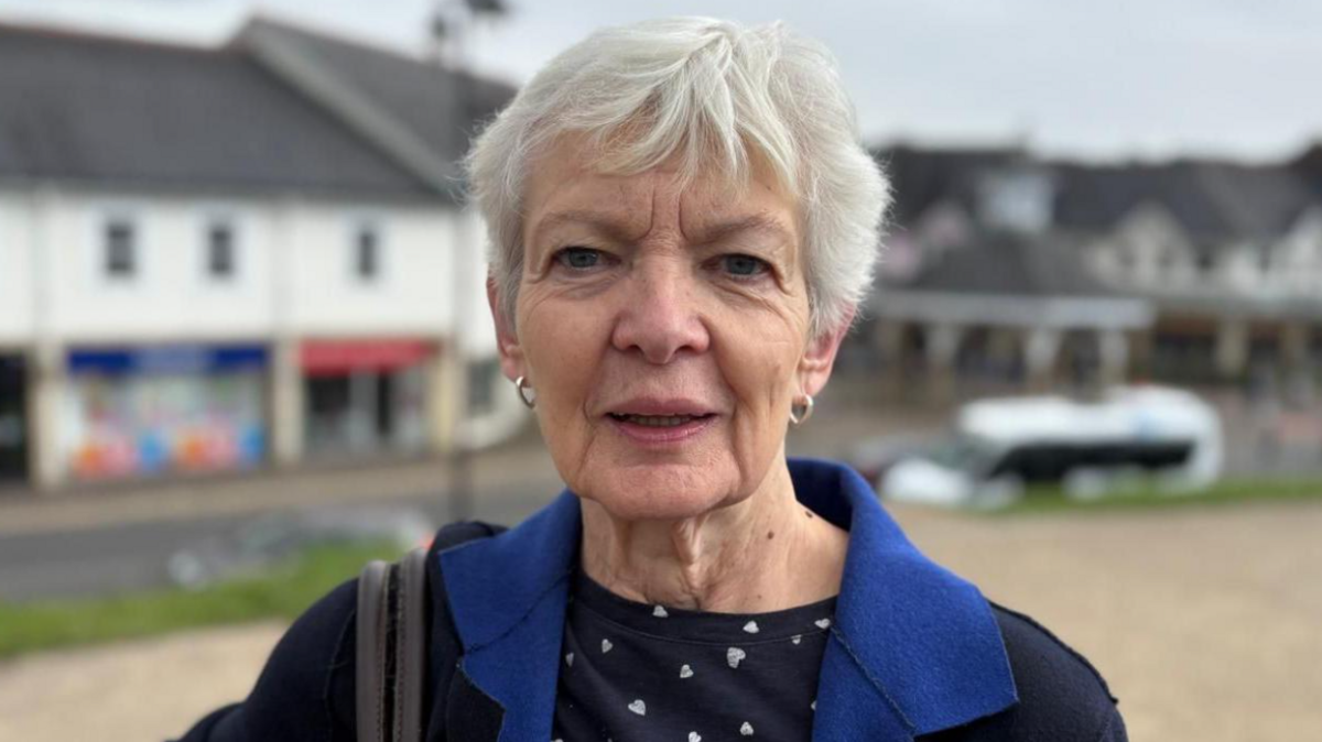 Ann Lewis yn sefyll yn yr ardal ger Castell Caerffili