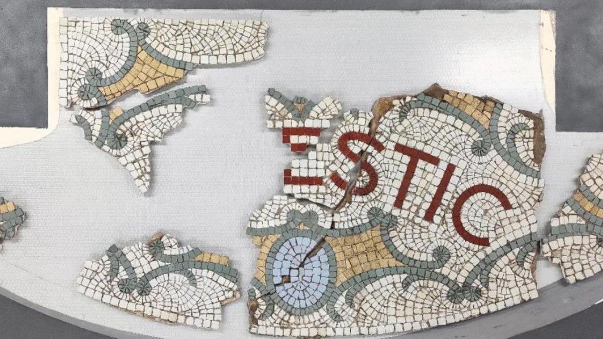 A picture of a broken mosaic. White, red, yellow and blue tiles are being pieced together.