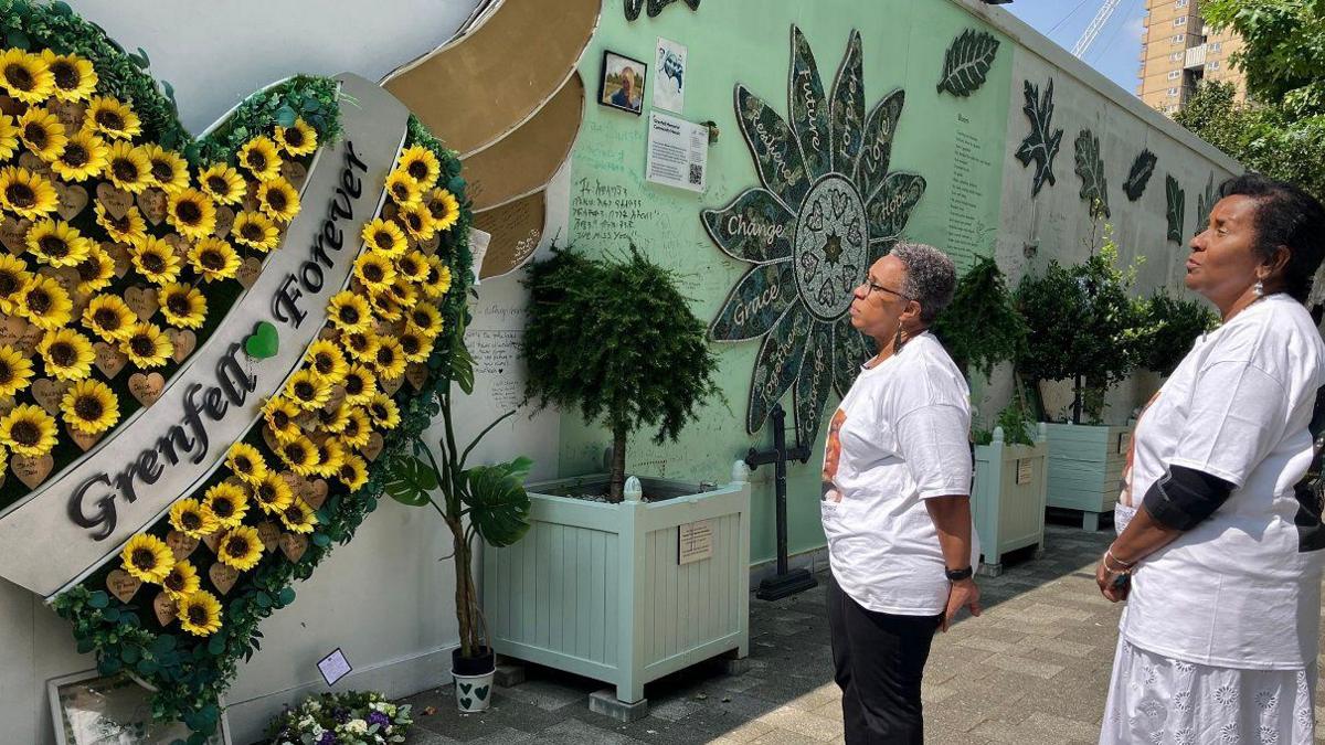 Jackie and Bernadette look at the memorial wall 