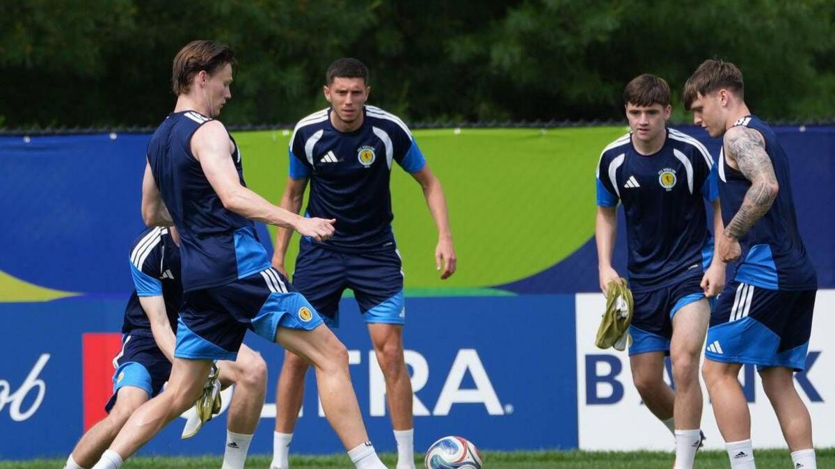 Scotland's players pass the ball around to each other in a small circle during a training drill