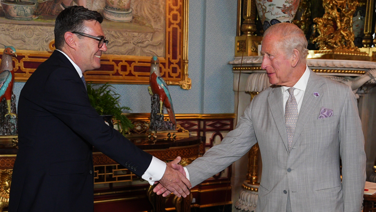 King Charles III shaking hands with Andy Burnham, during an audience at Buckingham Palace