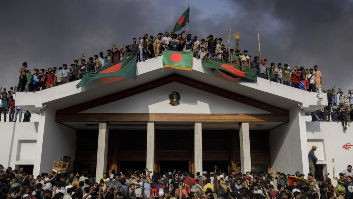 People gather around the residence of the Bangladeshi prime minister in Dhaka on 5 August