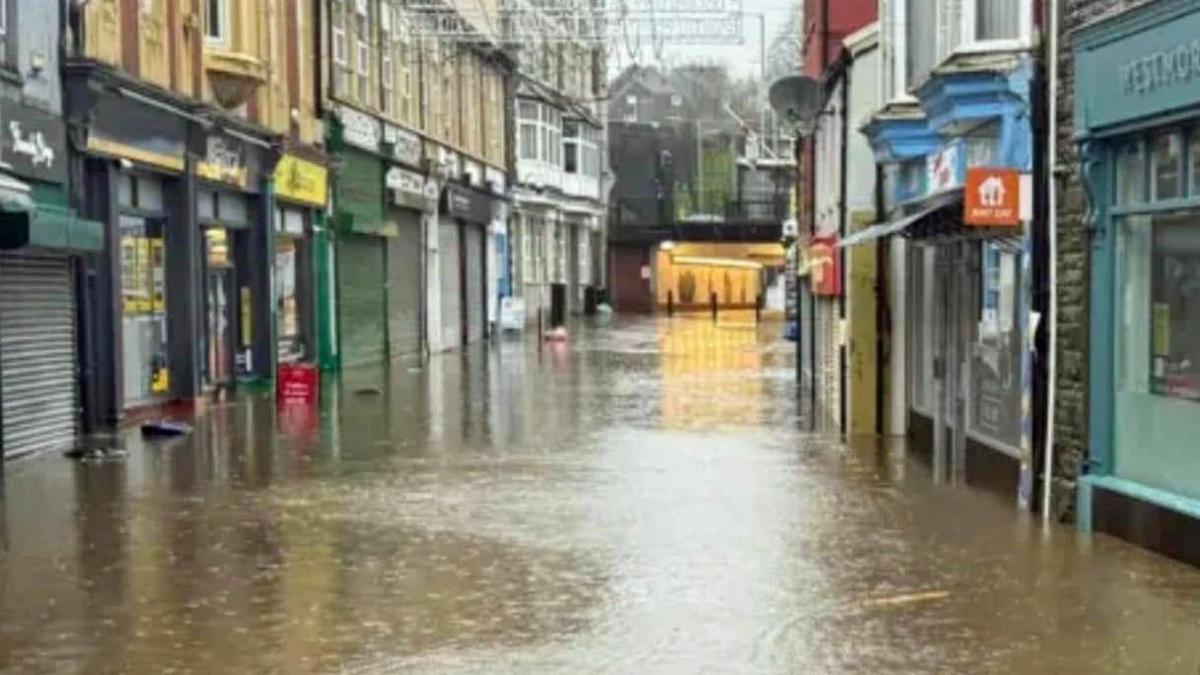 Mill Street, with shop fronts on either side and water covering the road