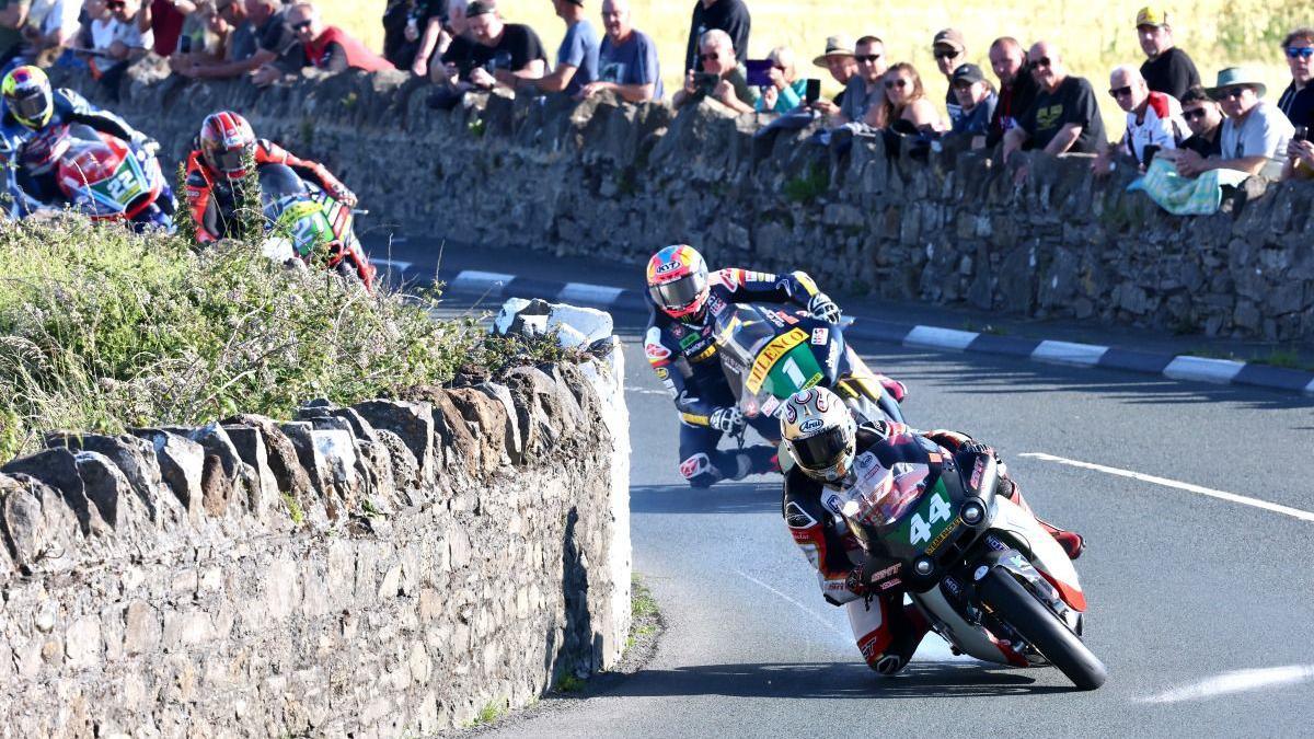 Rob Hodson leading Davey Todd on the road as spectators look on.