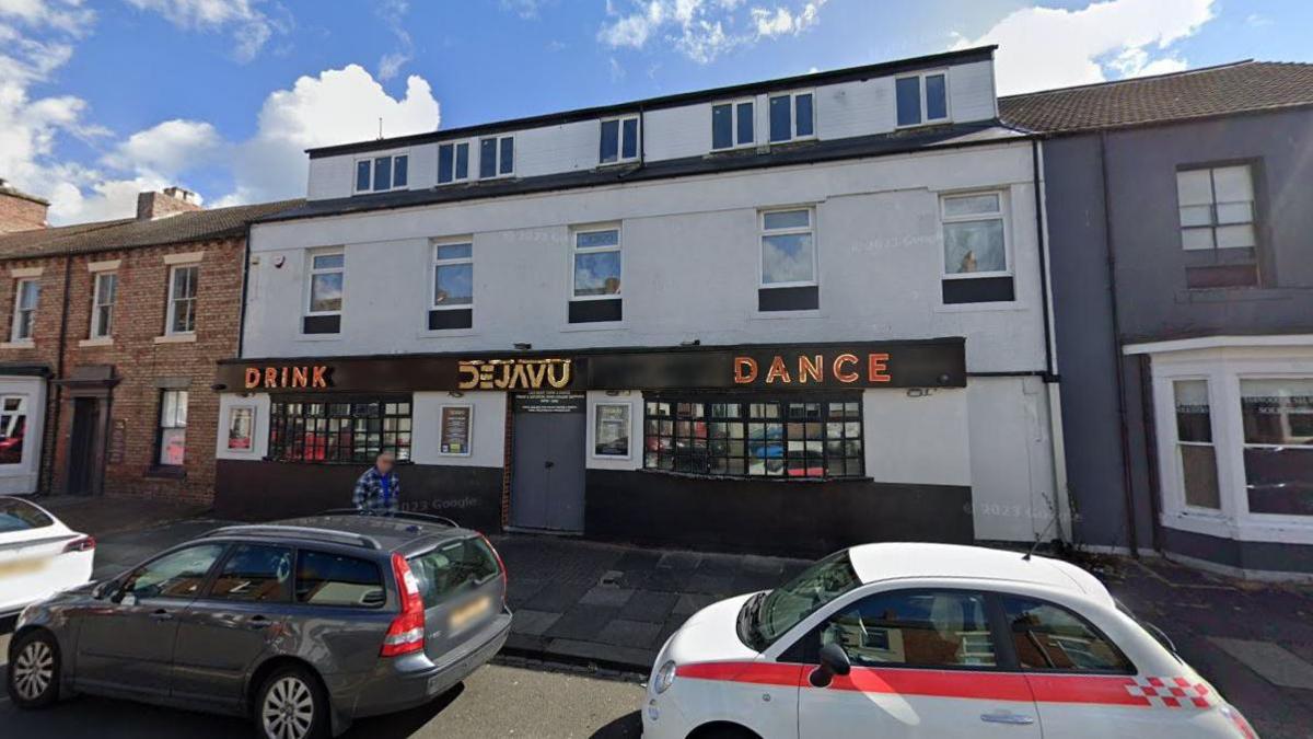 Street view of Dejavu. It it is a two-storey mid terrace building, with white halls and black fascias with the words "drink", "Dance" and "dejavu" in large gold letters